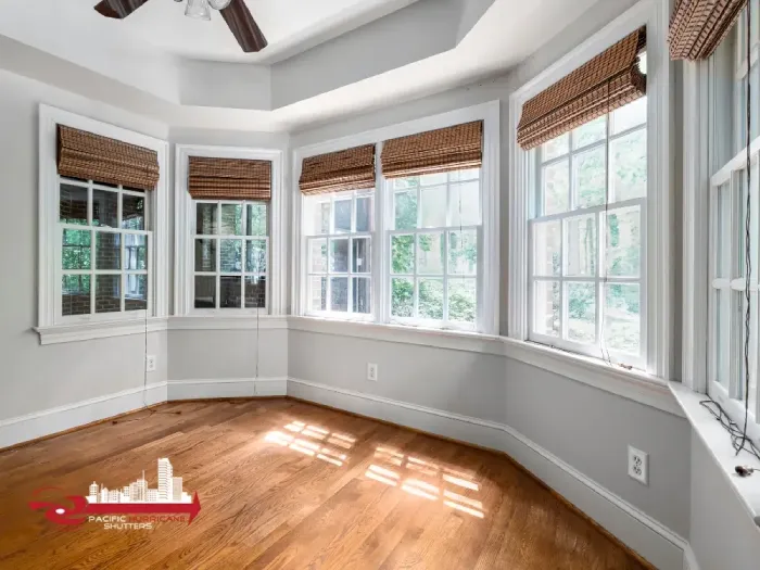 Sunlit interior with woven shades and tray ceiling—ideal for showcasing natural light and elegant design features.